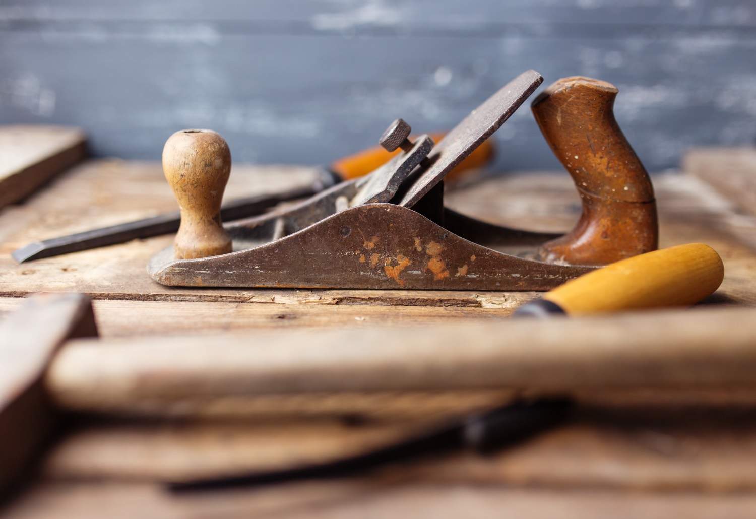 Old vintage hand tools on wooden background. Focus on jack-plane. Carpenter workplace.
